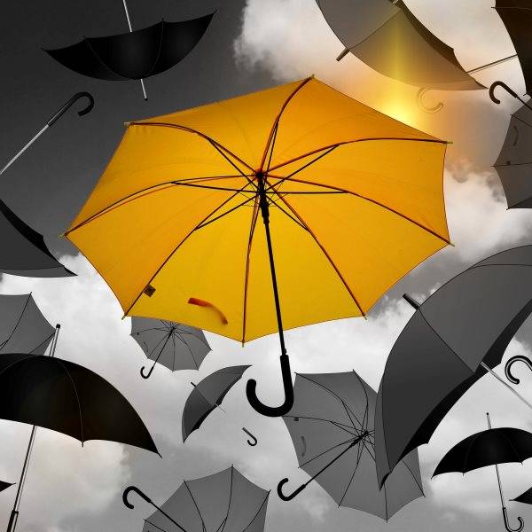 Quelle: Gerd Altmann auf pixabay Gelber Regenschirm schwebt unter mehreren schwarz-weißen Regenschirmen vor bewölktem Himmel